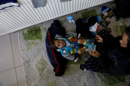 An Afghan migrant mother changes her child's nappies at a restaurant of a bus terminal, as they struggle to find buses to take them to western Turkish cities, after crossing the Turkey-Iran border in Agri, eastern Turkey, April 11, 2018. Picture taken April 11, 2018. REUTERS/Umit Bektas