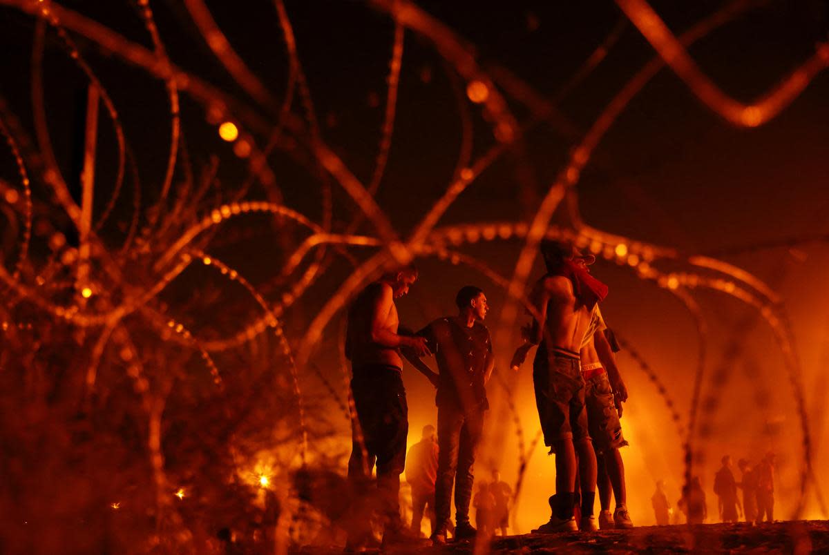 Migrants, mostly from Venezuela, gather near a wire fence after crossing the Rio Bravo river with the intention of turning themselves in to the U.S. Border Patrol agents to request asylum, in El Paso, Texas, U.S., September 22, 2023.