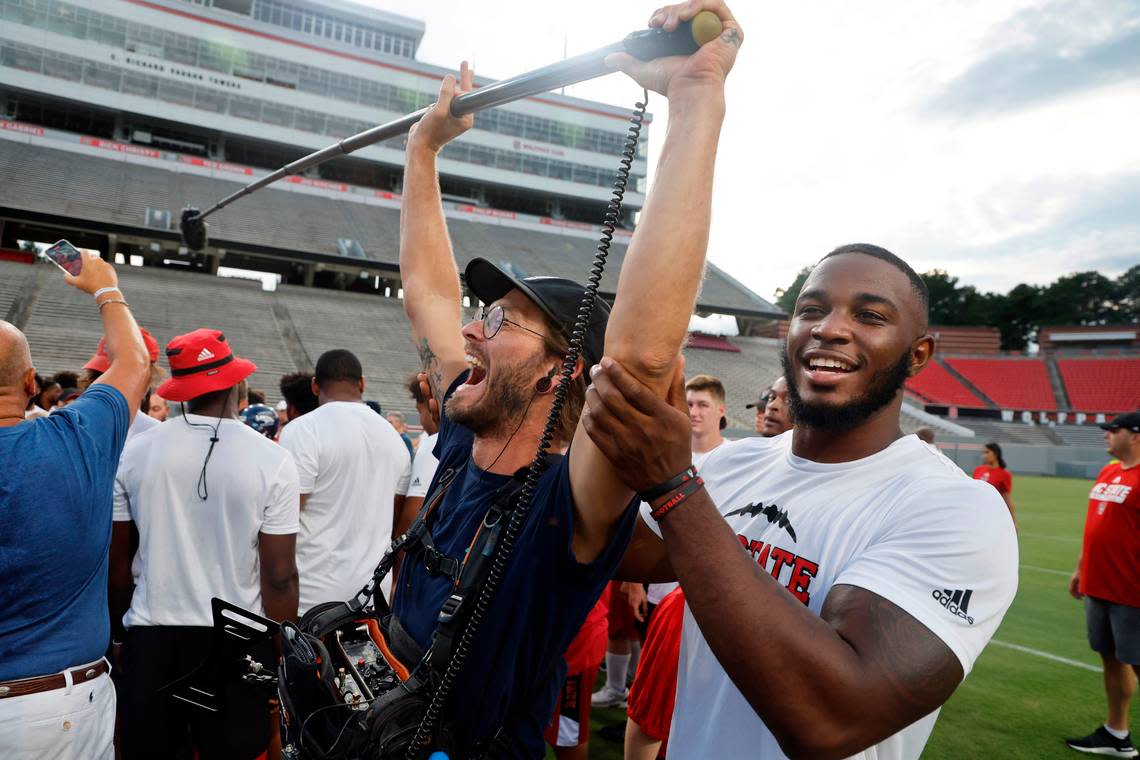 N.C. State’s Isaiah Moore helps keep the mic steady during a huddle on Victory Day at Carter-Finley Stadium in Raleigh, N.C., Friday, August 5, 2022.