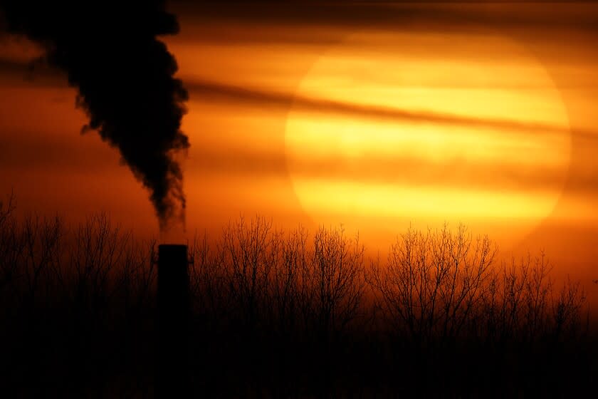 CORRECTS CITY TO KANSAS CITY FROM INDEPENDENCE - FILE - Emissions from a coal-fired power plant are silhouetted against the setting sun, Monday, Feb. 1, 2021, in Kansas City, Mo. (AP Photo/Charlie Riedel, File)