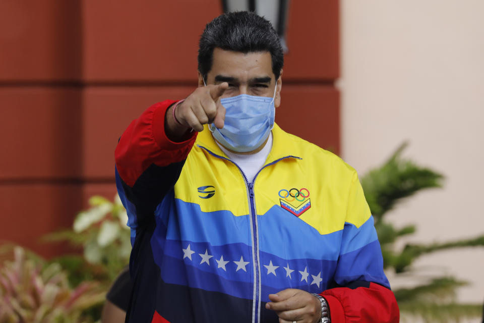 Venezuelan President Nicolas Maduro points to supporters during an event marking Youth Day at Miraflores presidential palace in Caracas, Venezuela, Friday, Feb. 12, 2021, amid the COVID-19 pandemic. The annual holiday commemorates young people who accompanied heroes in the battle for Venezuela's independence. (AP Photo/Ariana Cubillos)