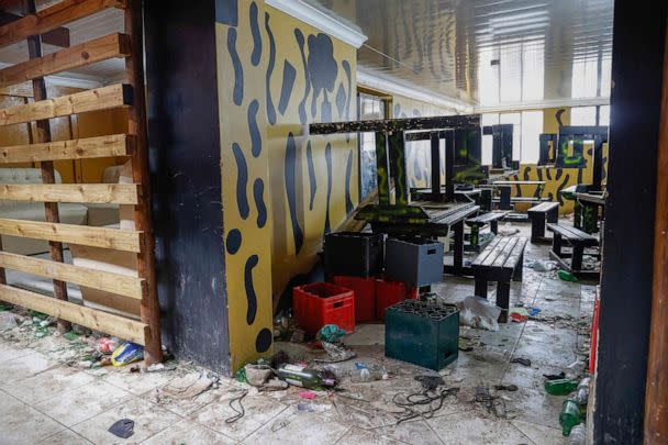 PHOTO: Empty alcohol bottles, crates, wooden chairs and tables are seen inside a township pub in southern city of East London on July 5, 2022, after the death of 21 teenagers in the establishment.  (Phill Magakoe/AFP via Getty Images)