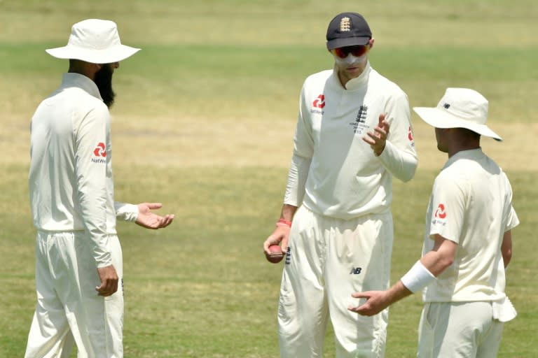 England captain Joe Root (C) speaks with spin bowlers Moeen Ali (L) and Mason Crane during their match against Australia XI in Townsville