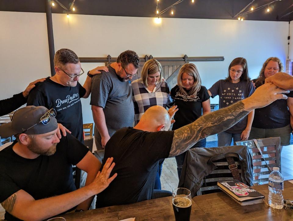 The Brew Pastors pray for Mike and Melissa Smith, co-owners of the Forever Craft Urban Winery in Plain Township's Oakwood Plaza, where the group met for nearly two years. The winery is set to close on Aug. 20.