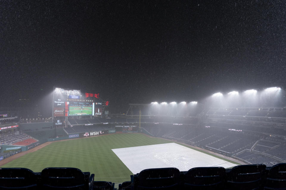 Heavy rain falls during a rain delay in the seventh inning of a baseball game between the Washington Nationals and the Los Angeles Dodgers, Friday, Sept. 8, 2023, in Washington. (AP Photo/Stephanie Scarbrough)