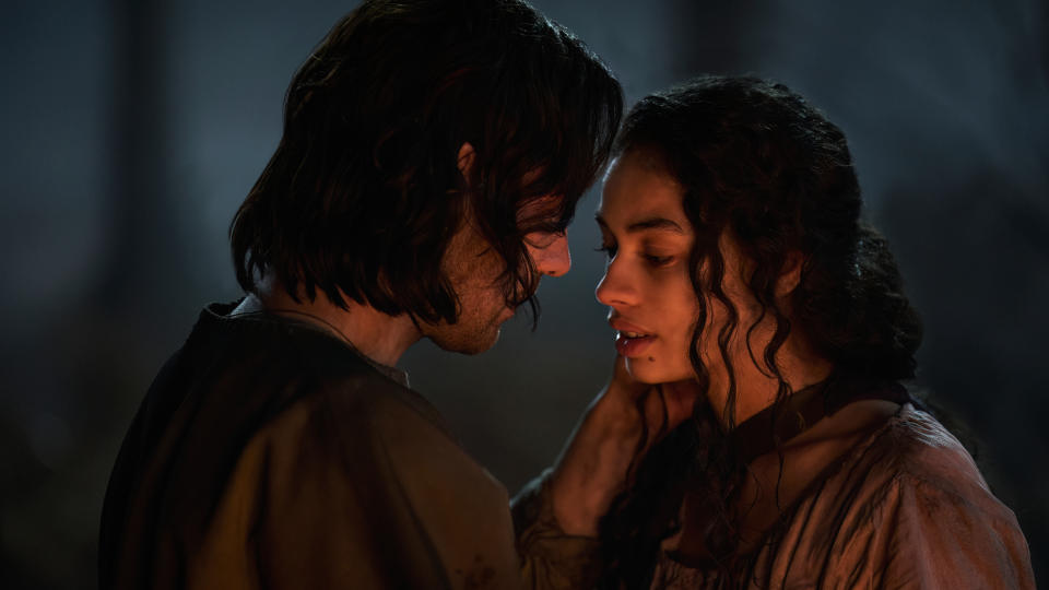 Isildur (Maxim Baldry) holds Estrid's (Nia Towle) face in a still from 