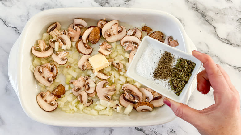 seasoning vegetables in baking dish