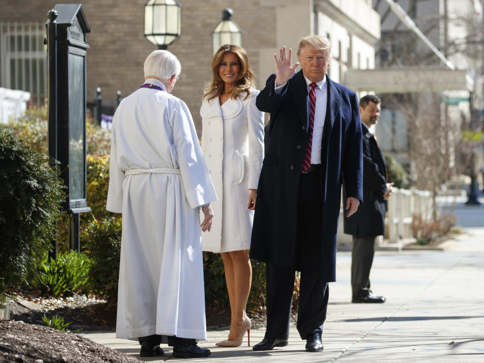 President Donald Trump with first lady Melania Trump, and Reverend Bruce McPherson, waves to media as he arrives to attend service at Saint John's Church in Washington, Sunday, March 17, 2019 (AP Photo/Carolyn Kaster)