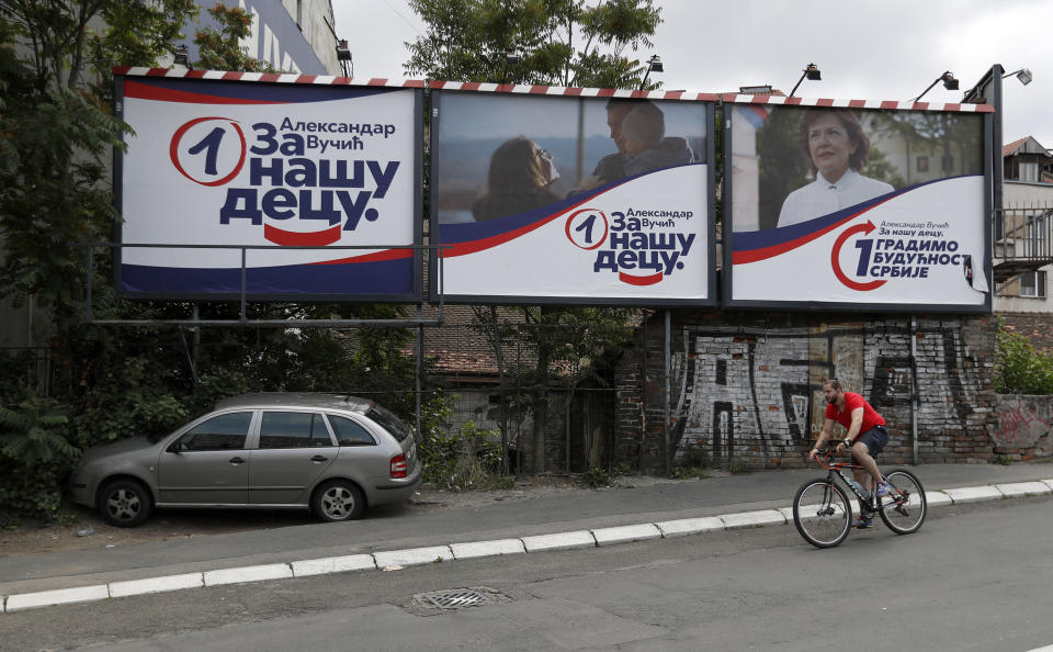 A man rides a bicycle by election billboards of the Serbian Progressive Party (SNS) reading: ''Aleksandar Vucic, for our children.'', in Belgrade, Serbia, Tuesday, June 16, 2020. Most of the main opposition parties plan to boycott the vote because of Serbian President Aleksandar Vucic's firm control of media and the electoral process. Vucic and his allies have denounced the boycott, saying it includes groups that would anyway not get enough votes to make it into Serbia's 250-seat parliament. (AP Photo/Darko Vojinovic)