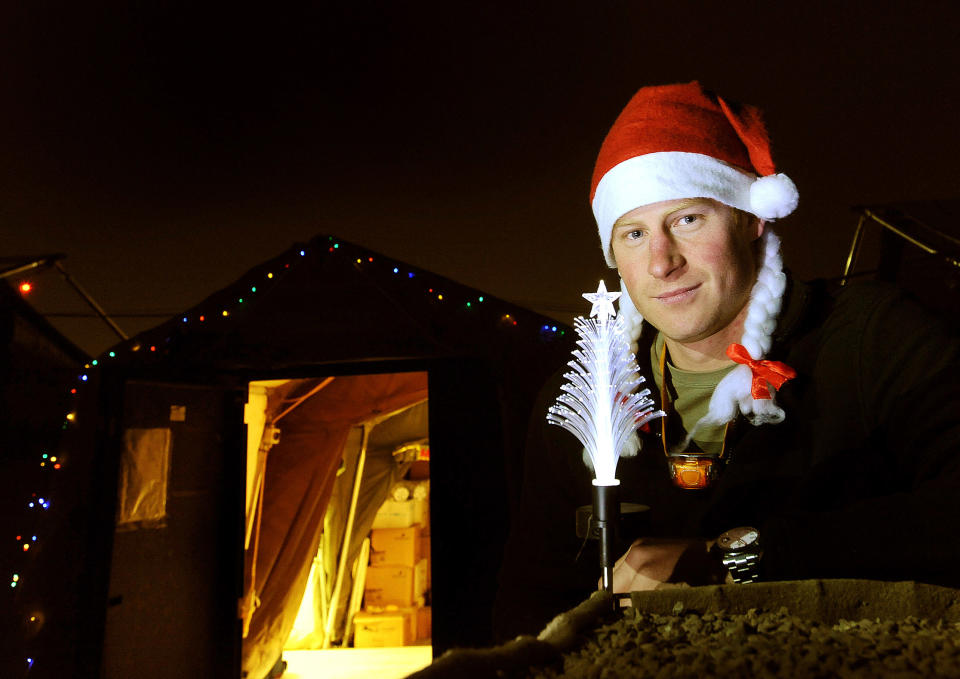 CAMP BASTION, AFGHANISTAN - DECEMBER 12:  In this previously unissued image released on January 27, 2013, Prince Harry poses with a Christmas hat as he stands outside the VHR (very high readiness) tent at Camp Bastion on December 12, 2012 in Afghanistan. Prince Harry has served as an Apache Helicopter Pilot/Gunner with 662 Sqd Army Air Corps, from September 2012 for four months until January 2013. (Photo by John Stillwell - WPA Pool/Getty Images)