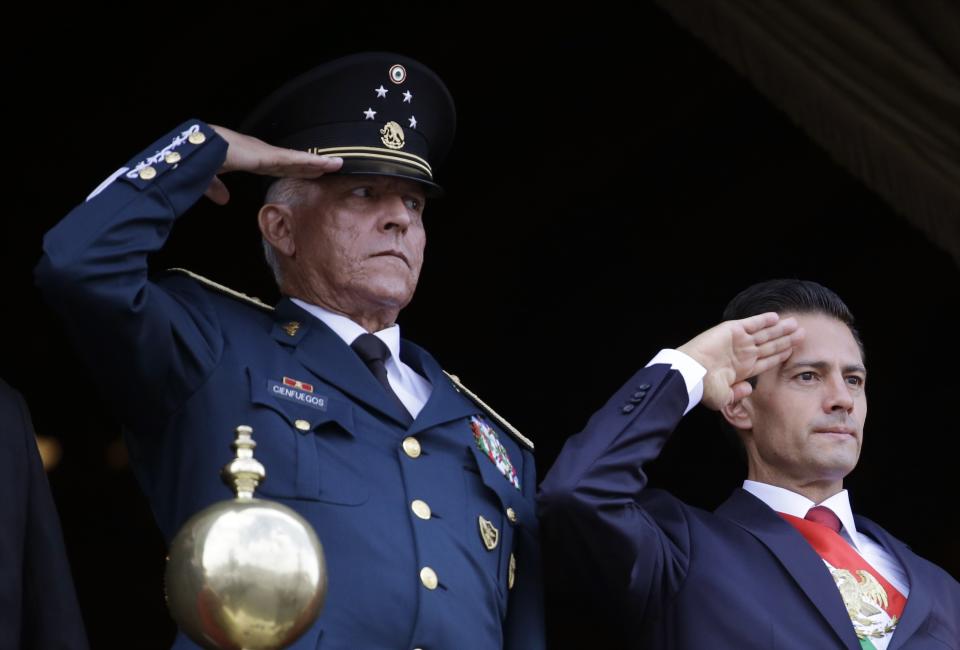 FILE - In this Sept. 16, 2016 file photo, Defense Secretary Gen. Salvador Cienfuegos, left, and Mexico's President Enrique Pena Nieto, salute during the annual Independence Day military parade in Mexico City's main square. Mexico's top diplomat says the country's former defense secretary, Gen. Salvador Cienfuegos, has been arrested in Los Angeles. Foreign Relations Secretary Marcelo Ebrard wrote Thursday, Oct. 15, 2020 in his Twitter account that U.S. Ambassador Christopher Landau had informed him of Cienfuegos' arrest. (AP Photo/Rebecca Blackwell, File)