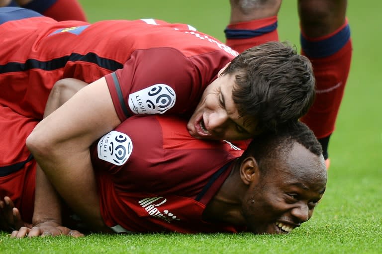 Lille's defender Stoppila Sunzu (C) is congratulated by his teammates after scoring against Nantes on April 3, 2016