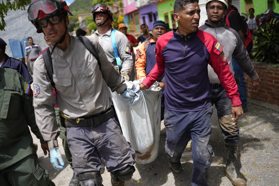 The body of seven-year-old Angel Senprum is brought to a community health center amid flooding in Las Tejerias, Venezuela, Monday, Oct. 10, 2022. A fatal landslide fueled by flooding and days of torrential rain swept through this town in central Venezuela. (AP Photo/Matias Delacroix)