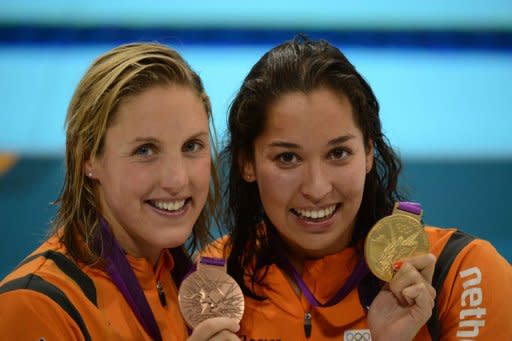 Netherlands' Ranomi Kromowidjojo (R) poses on the podium with the gold medal flanked by silver medalist Netherlands' Marleen Veldhuis after winning the women's 50m freestyle final during the swimming event at the London 2012 Olympic Games