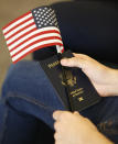 FILE - In this Aug. 30, 2018, file photo, a new citizens holds an American flag and passport during a naturalization ceremony at the U.S. Citizenship and Immigration Services Kendall Field Office in Miami. A growing number of Americans say immigration should remain the same or be increased since the Trump administration ramped up immigration enforcement. That's according to the General Social Survey, which has also found a growing partisan divide on the topic. The poll shows 34 percent of Americans want immigration to be reduced, down from 41 percent in 2016. It's the first time since the question was asked in 2004 that more Americans want immigration levels to stay the same than to be reduced. (AP Photo/Wilfredo Lee, File)