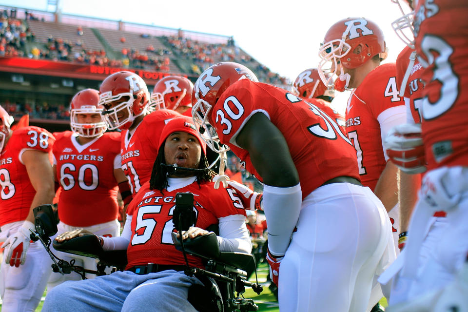 NEW BRUNSWICK, NJ - NOVEMBER 19: Eric LeGrand #52 of the Rutgers Scarlet Knights posses for a photo with teammates on Senior's Day at center field before a game against Cincinnati Bearcats at Rutgers Stadium on November 19, 2011 in New Brunswick, New Jersey. LeGrand was paralyzed during a kickoff return in October 2010. (Photo by Patrick McDermott/Getty Images)