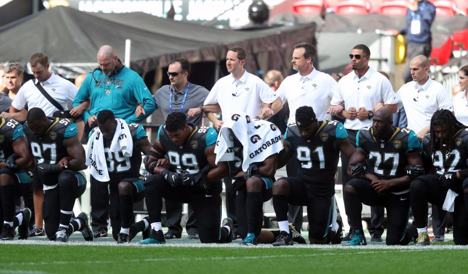 Baltimore Ravens kneel at the playing of the American National Anthem