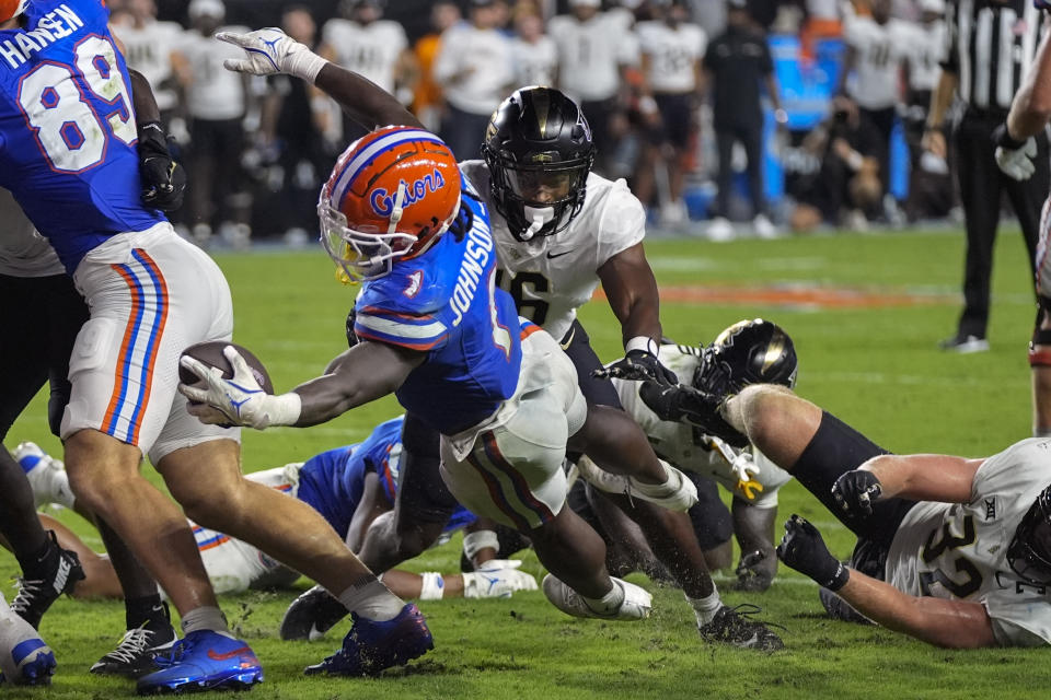 Florida running back Montrell Johnson Jr. (1) dives over the goal line in front of Central Florida linebacker TJ Bullard, center to score a touchdown on a 3-yard run during the first half of an NCAA college football game, Saturday, Oct. 5, 2024, in Gainesville, Fla. (AP Photo/John Raoux)