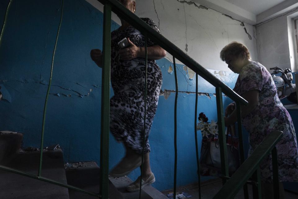 64-year-old Tetiana Solohub, left, walks up with her friend to see her apartment destroyed from Russian aerial bombs, in Borodyanka, Kyiv region, Ukraine, Tuesday, June 28, 2022. "And now, at 64, I am forced to be homeless," Solohub said. She doesn't have a damaged apartment to live in. Hers is completely gone. Solohub now lives in a camp made of shipping containers. (AP Photo/Nariman El-Mofty)