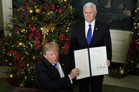 U.S. President Donald Trump shows off an executive order recognizing Jerusalem as the capital of Israel after signing it with Vice President Mike Pence at his side in the Diplomatic Reception Room of the White House in Washington, U.S., December 6, 2017. REUTERS/Jonathan Ernst