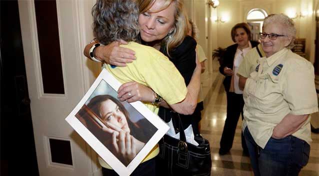 Debbie Ziegler holds a photo of her daughter, Brittany Maynard, as she receives congratulations from Ellen Pontac, after a right-to die measure was approved by the state Assembly. Photo: AP