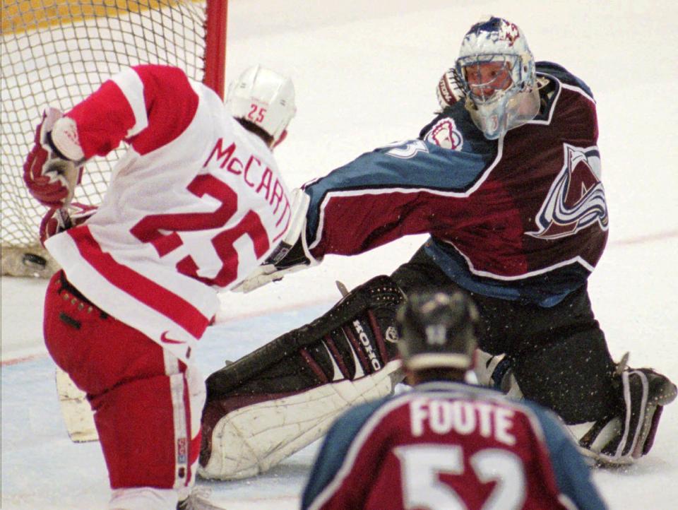 Detroit Red Wings' Darren McCarty scores the winning goal in overtime past Colorado Avalanche goaltender Patrick Roy in Detroit on March 26, 1997. Detroit won 6-5.