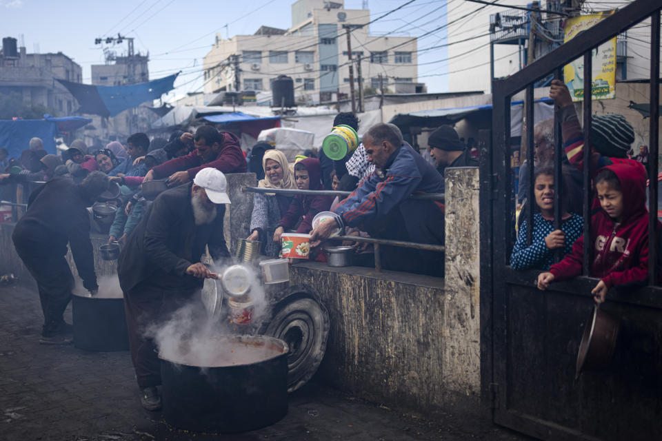 Palestinians line up for a free meal in Rafah, Gaza Strip, Friday, Feb. 16, 2024. International aid agencies say Gaza is suffering from shortages of food, medicine and other basic supplies as a result of the war between Israel and Hamas. (AP Photo/Fatima Shbair)