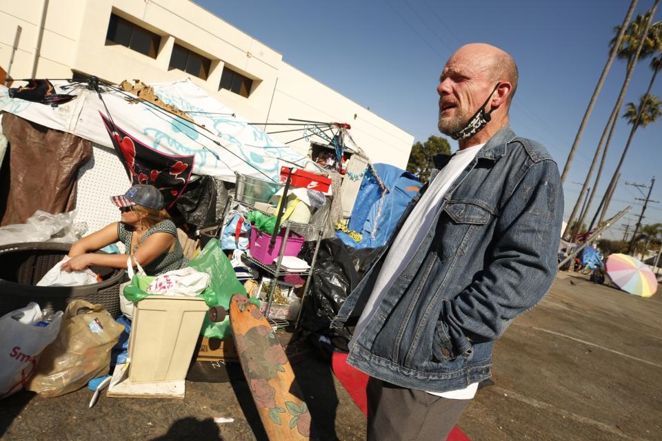 A man who calls himself Arkansas visits with Elisabeth Axiotis, who camps in a Venice parking lot