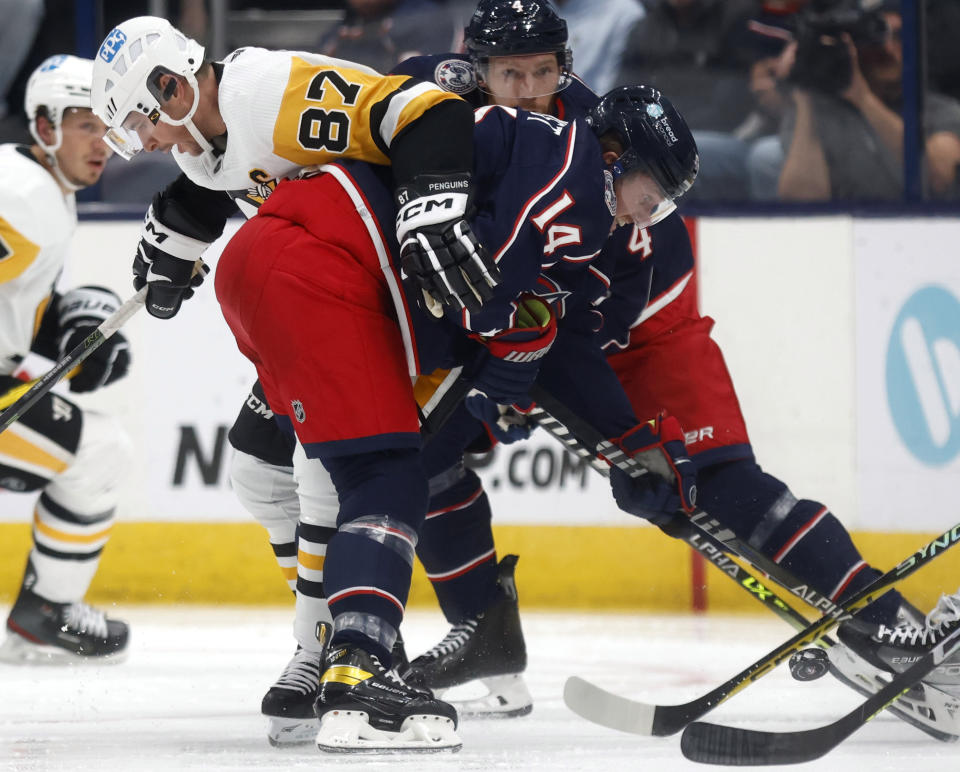 Pittsburgh Penguins forward Sidney Crosby, left, works against Columbus Blue Jackets forward Gustav Nyquist during the second period of an NHL hockey game in Columbus, Ohio, Saturday, Oct. 22, 2022. (AP Photo/Paul Vernon)