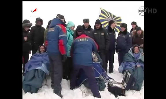 The recovery team attends to NASA astronaut Mike Hopkins and cosmonauts Oleg Kotov and Sergey Ryazanskiy after the trio's Soyuz capsule touched down in frigid Kazakhstan on March 10, 2014.