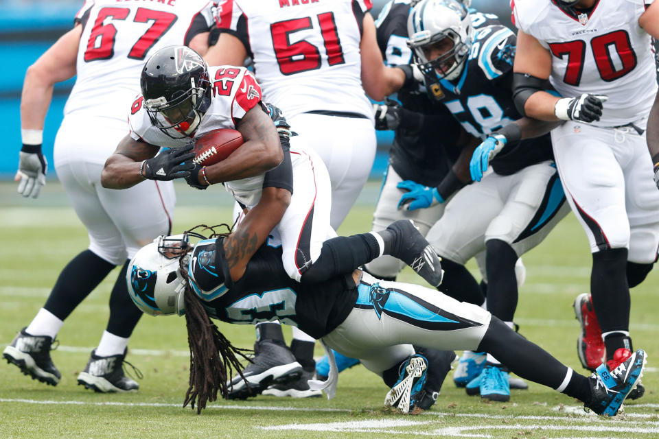 Atlanta Falcons’ Tevin Coleman runs over Carolina Panthers’ Tre Boston in Charlotte, N.C.