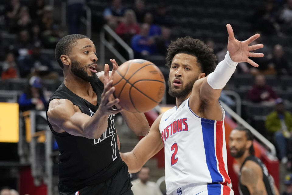 Brooklyn Nets forward Mikal Bridges (1) passes the ball as Detroit Pistons guard Cade Cunningham (2) defends during the first half of an NBA basketball game, Thursday, March 7, 2024, in Detroit. (AP Photo/Carlos Osorio)