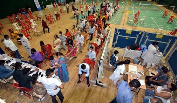 People line up for the COVID-19 vaccine at a stadium in Guwahati, India, on Thursday. Several hospitals, including Shanti Mukand in the west of the New Delhi said they had almost exhausted their oxygen supplies on Thursday. 