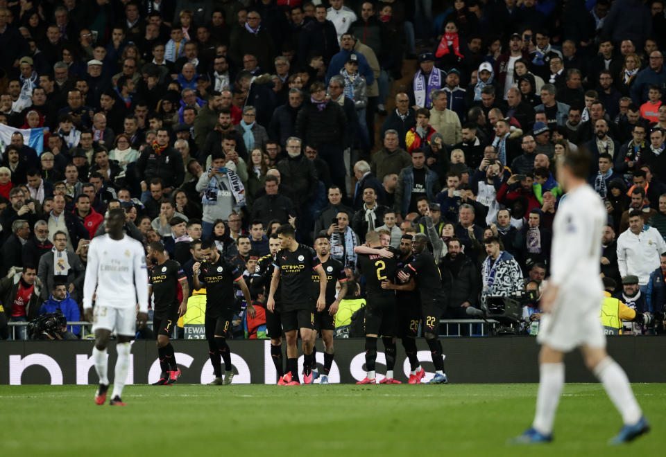 Manchester City's Kevin De Bruyne celebrates with teammates after scores his side's second goal from the penalty spot during the Champions League, round of 16, first leg soccer match between Real Madrid and Manchester City at the Santiago Bernabeu stadium in Madrid, Spain, Wednesday, Feb. 26, 2020. (AP Photo/Manu Fernandez)