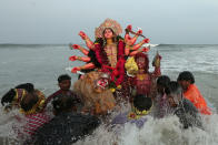 <p>Devotees immerse an idol of the Hindu goddess Durga into the Bay of Bengal on the last day of the Durga Puja festival in Chennai, India, Sept. 30, 2017 . (Photo: P. Ravikumar/Reuters) </p>