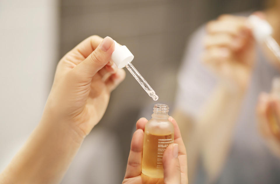 bottle of collagen serum in woman's hand