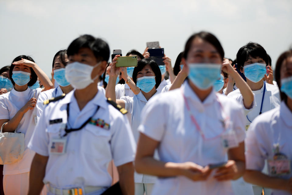 Medical workers watch the 'Blue-Impulse' aerobatic team of Japan Air Self-Defense Force as they fly over the Self-Defense Forces Central Hospital to salute the medical workers at the frontline of the fight against the coronavirus disease (COVID-19) in Tokyo, Japan May 29, 2020. (Issei Kato/Reuters)