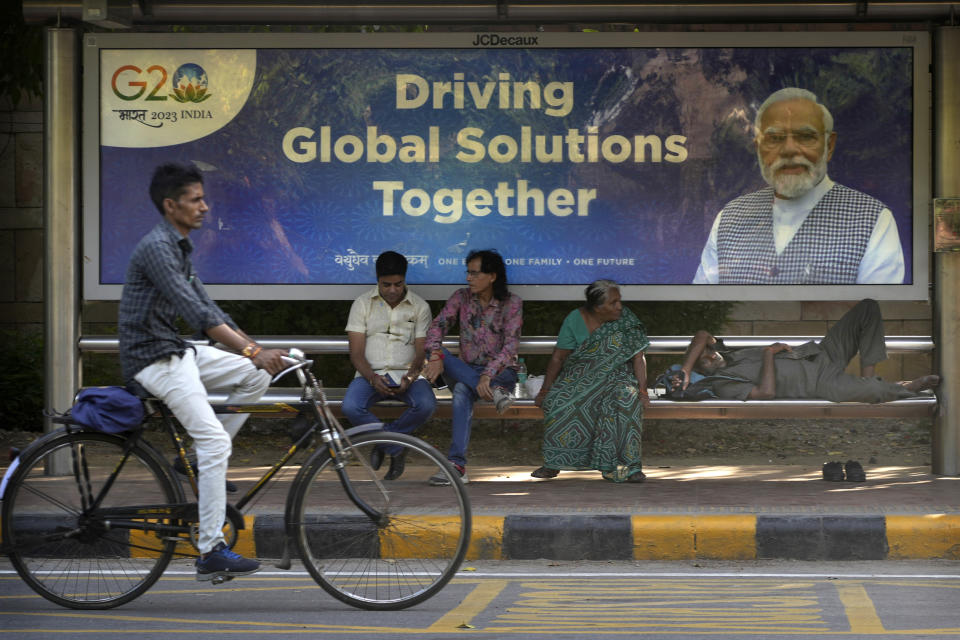 A cyclist rides past a bus waiting shelter with a poster of Indian Prime Minister Narendra Modi ahead of this week's summit of the Group of 20 nations in New Delhi, India, Monday, Sept. 4, 2023. The Indian government has seized upon its role as host of this year's G20 summit and mounted an advertising blitz that stresses India's growing clout under Prime Minister Narendra Modi. (AP Photo/Manish Swarup)