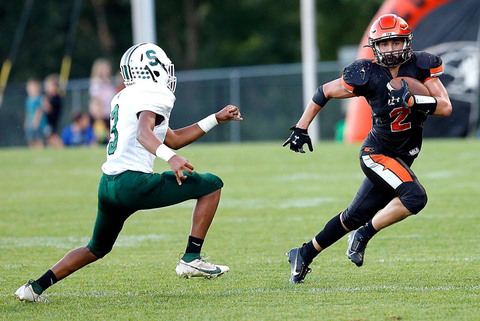 Lucas High School's Logan Toms (2) carries the ball as Smithville High School's Isaiah Beery (3) moves in for a tackle during high school football action at Lucas High School, Friday, Sept. 1, 2023. TOM E. PUSKAR/MANSFIELD NEWS JOURNAL