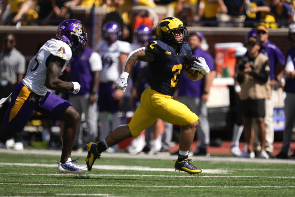 Michigan running back Blake Corum (2) runs from East Carolina defensive back Isaiah Brown-Murray (26) in the first half of an NCAA college football game in Ann Arbor, Mich., Saturday, Sept. 2, 2023. (AP Photo/Paul Sancya)