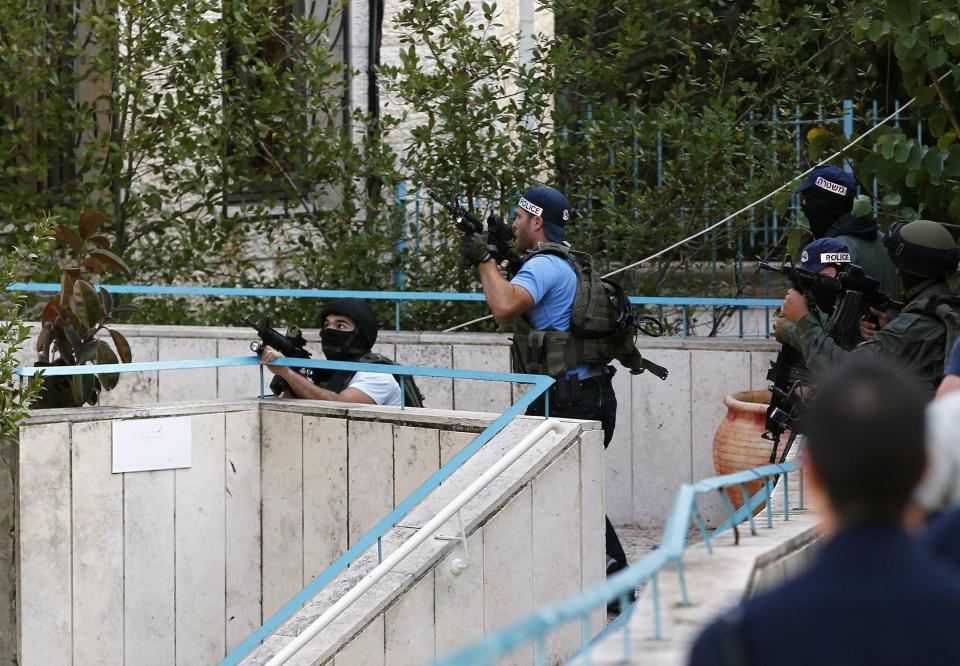 Israeli police officers take position near the scene of an attack at a Jerusalem synagogue