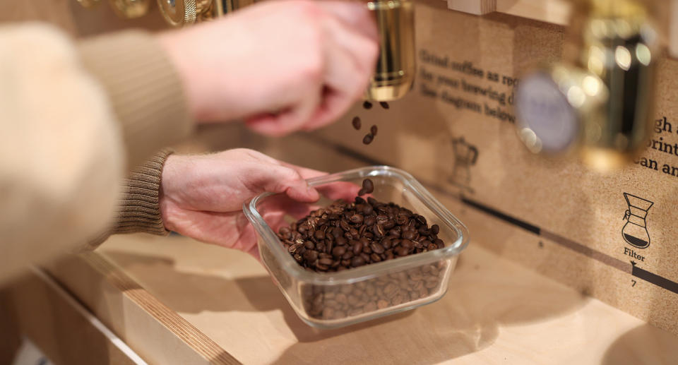 A person pours coffee into a container.