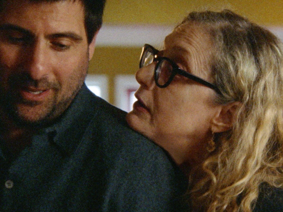 jason schwartzman and carol kane as ben and carla in between the temples. carla has her chin reting on ben's shoulder, as he looks over toward her