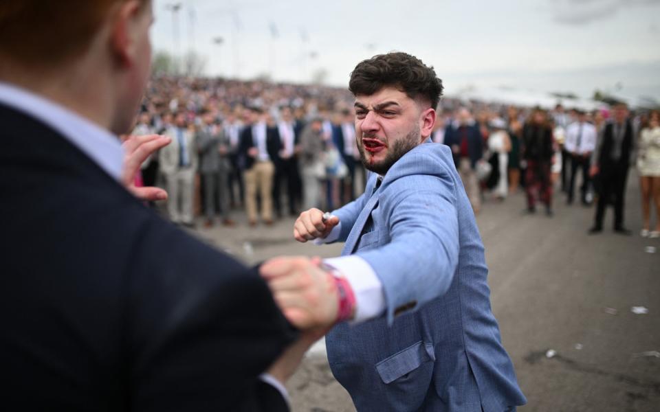 Racegoers fight each other as they scuffle on the second day of the Grand National