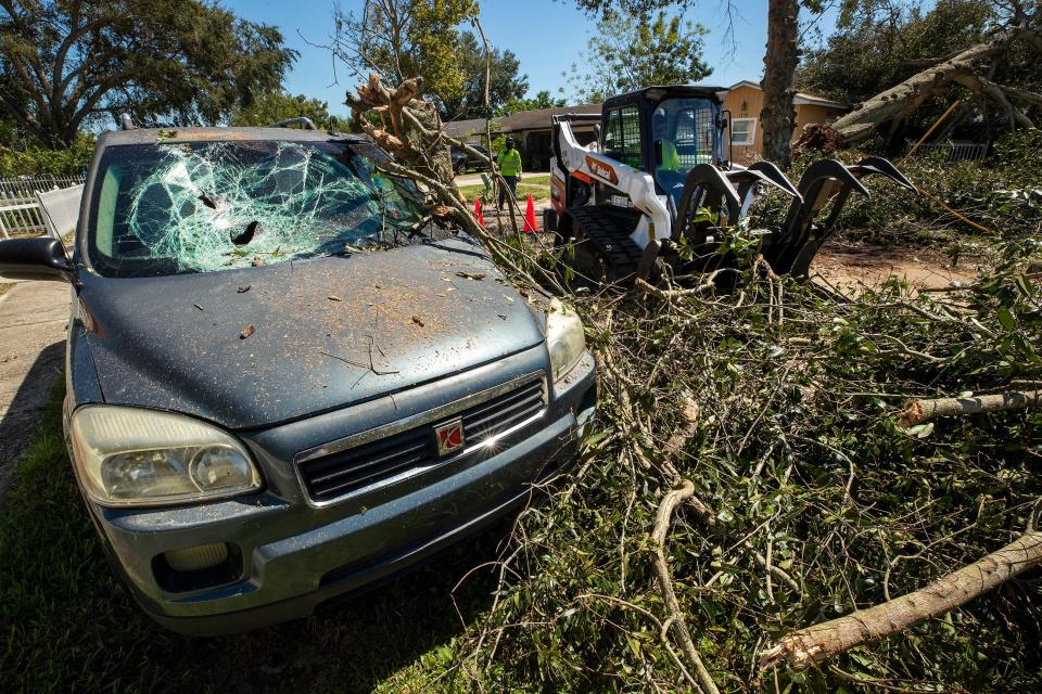 A large oak tree knocked over by Hurricane Ian crushed a vehicle on Avenue C NE In Winter Haven  Fl. Friday September 30,2022Ernst Peters/.The Ledger