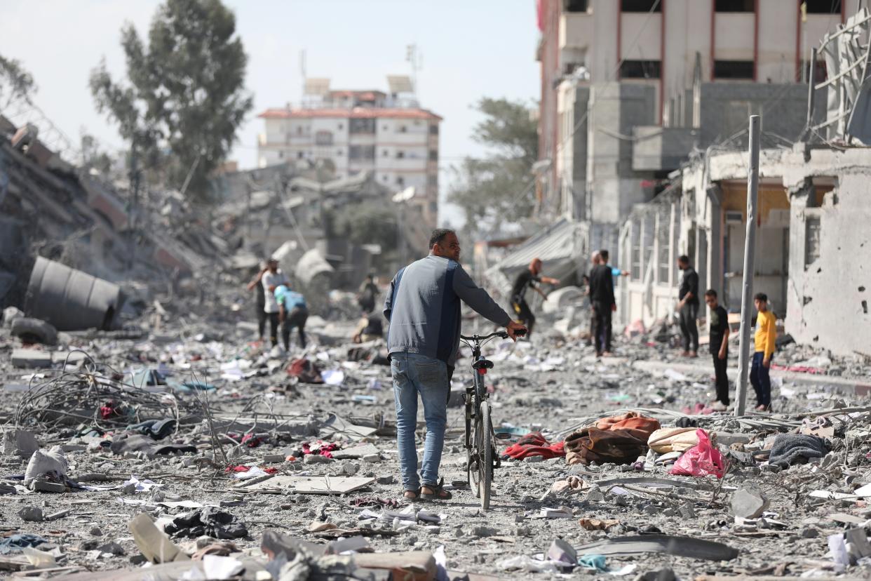 Palestinians walk by the buildings destroyed in the Israeli bombardment on al-Zahra on the outskirts of Gaza City on Friday (Copyright 2023 The Associated Press. All rights reserved.)