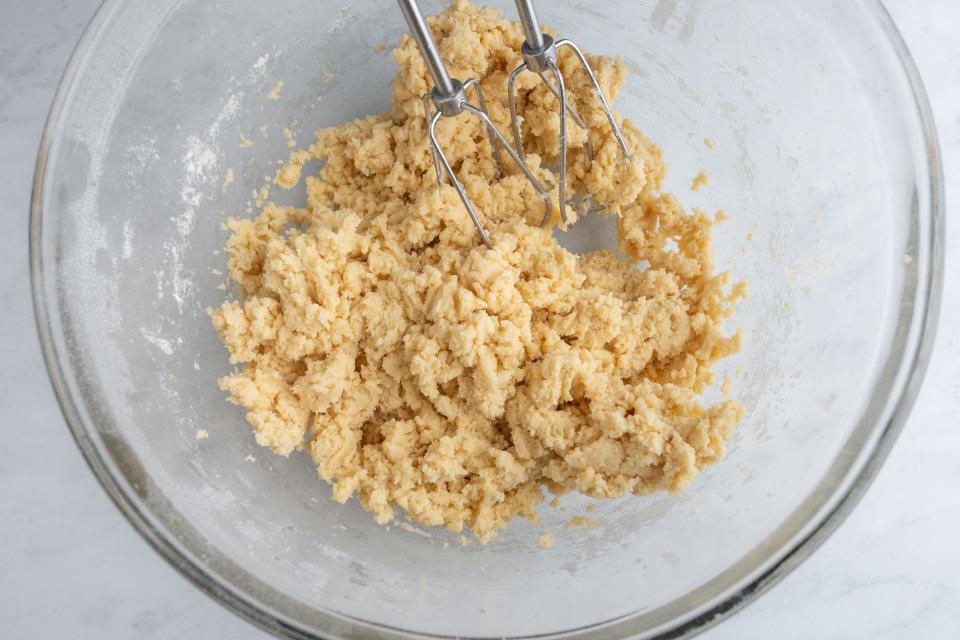 Slightly crumbly, wet sugar-cookie dough in a glass bowl