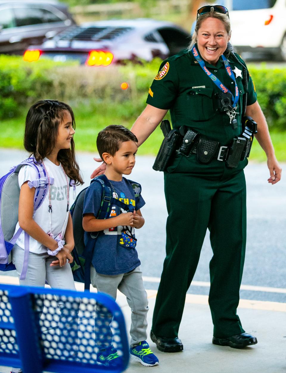Shady Hill Elementary School Resource Officer Rochelle Mims welcomes Zoey Rivera, 7, and her brother Liam, 5, to the first day of school on Aug. 10.
