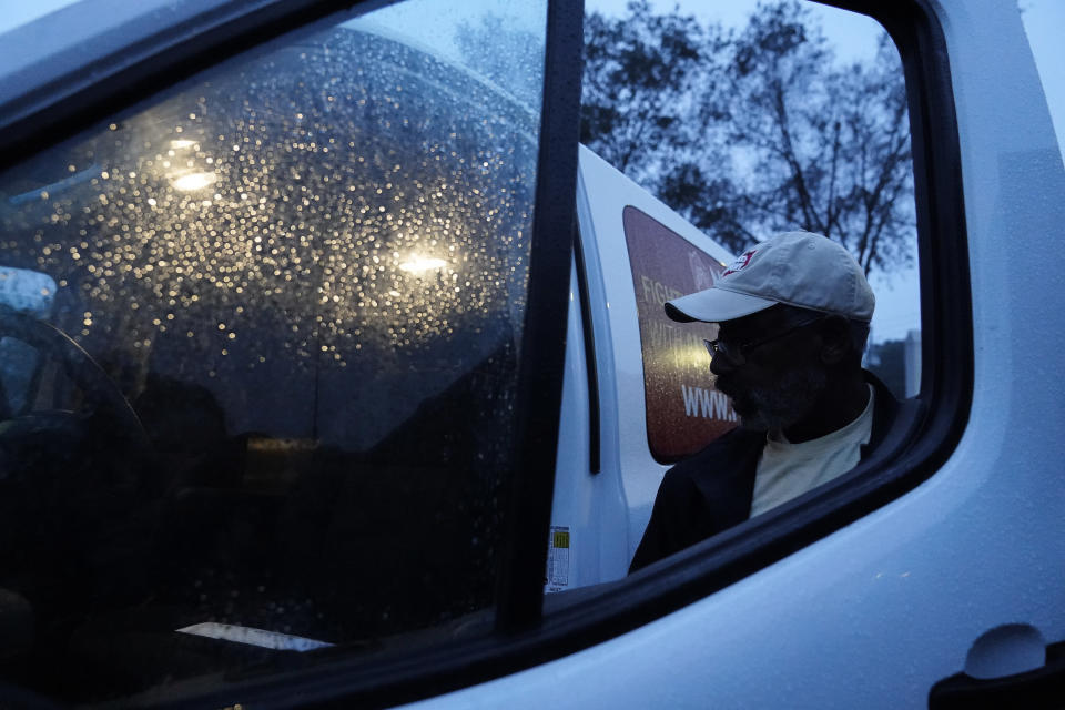 Neighborhood Assistance Corporations of America, employee, Malcom Williams, 65, of Loganville, Ga., gets into a NACA van, for a "Roll to the Polls" daily event to help usher voters for early voting on Wednesday, Oct. 28, 2020, in Decatur, Ga. The vans have carted 25,000 people to the polls, said media coordinator Tim Trumble. (AP Photo/Brynn Anderson)