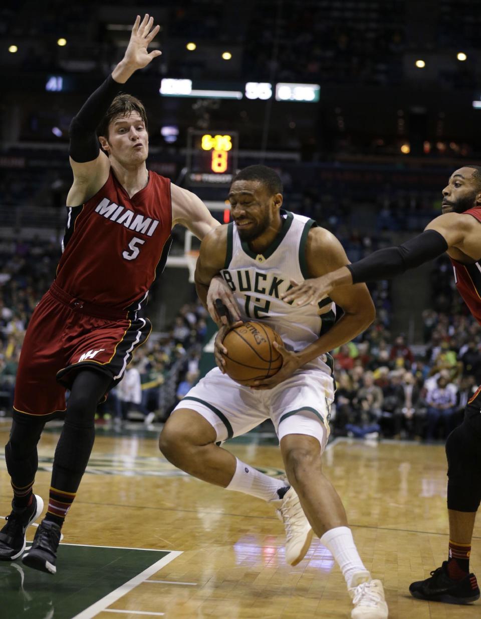 Milwaukee Bucks' Jabari Parker (12) grimaces as he drives against the Miami Heat's Luke Babbitt during the second half of an NBA basketball game Wednesday, Feb. 8, 2017, in Milwaukee. Parker was injured on the play and left the game. (AP Photo/Jeffrey Phelps)